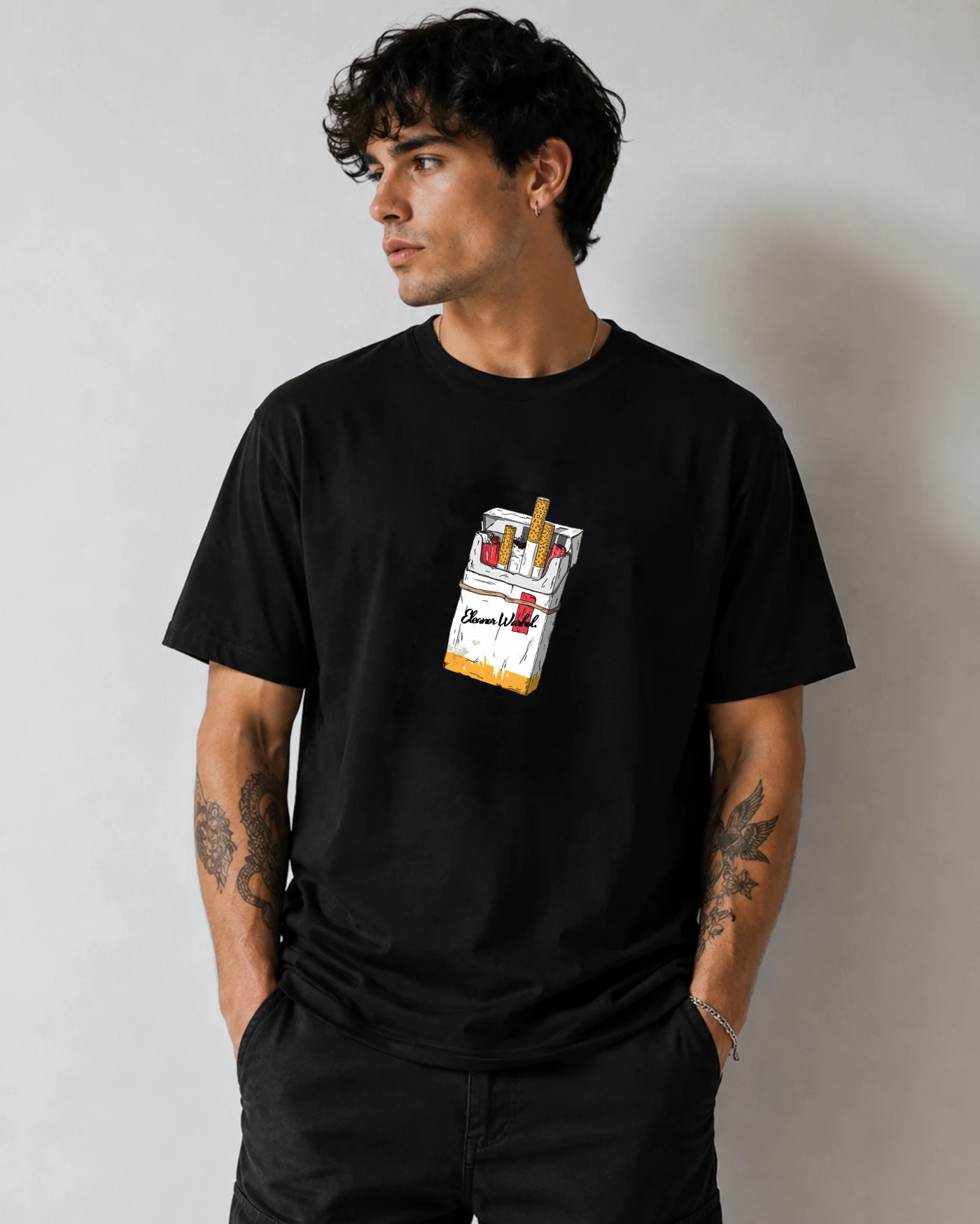 Model in a black tee with a hand-drawn cigarette pack printed high on the chest