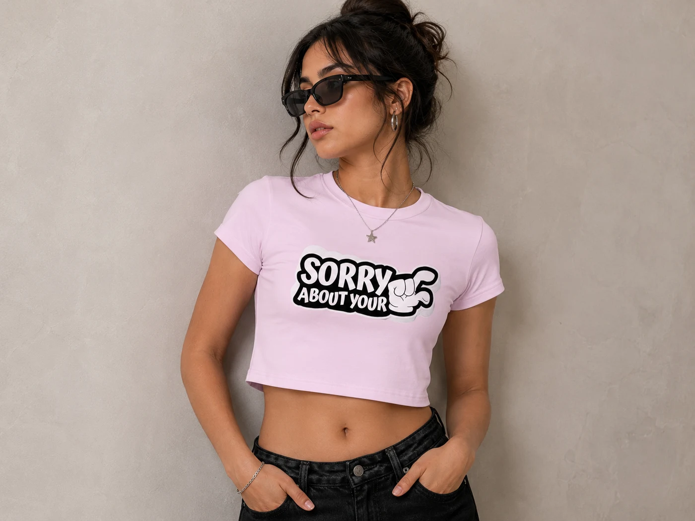 Model in a pink cropped tee with a cartoon hand graphic across the chest