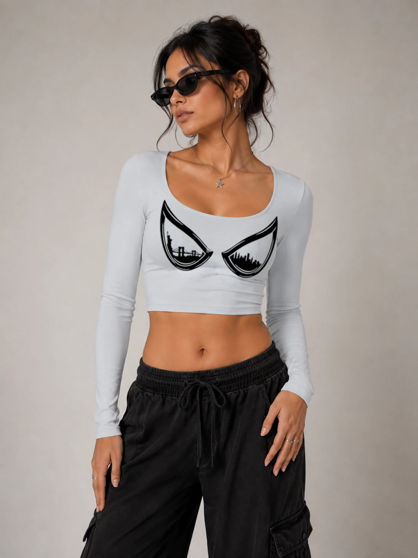 Model in a grey long sleeve crop top with an eyes graphic across the chest